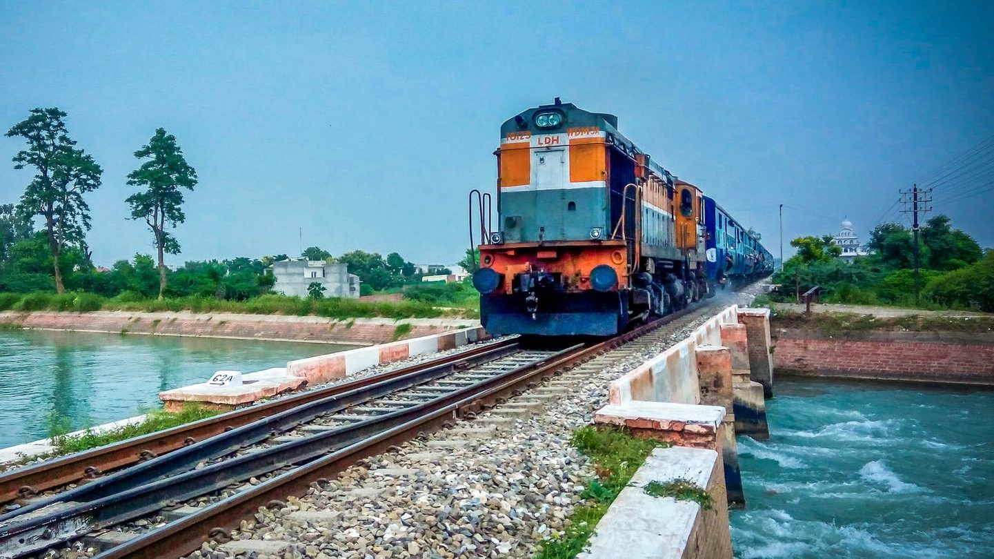 train by trees against blue sky