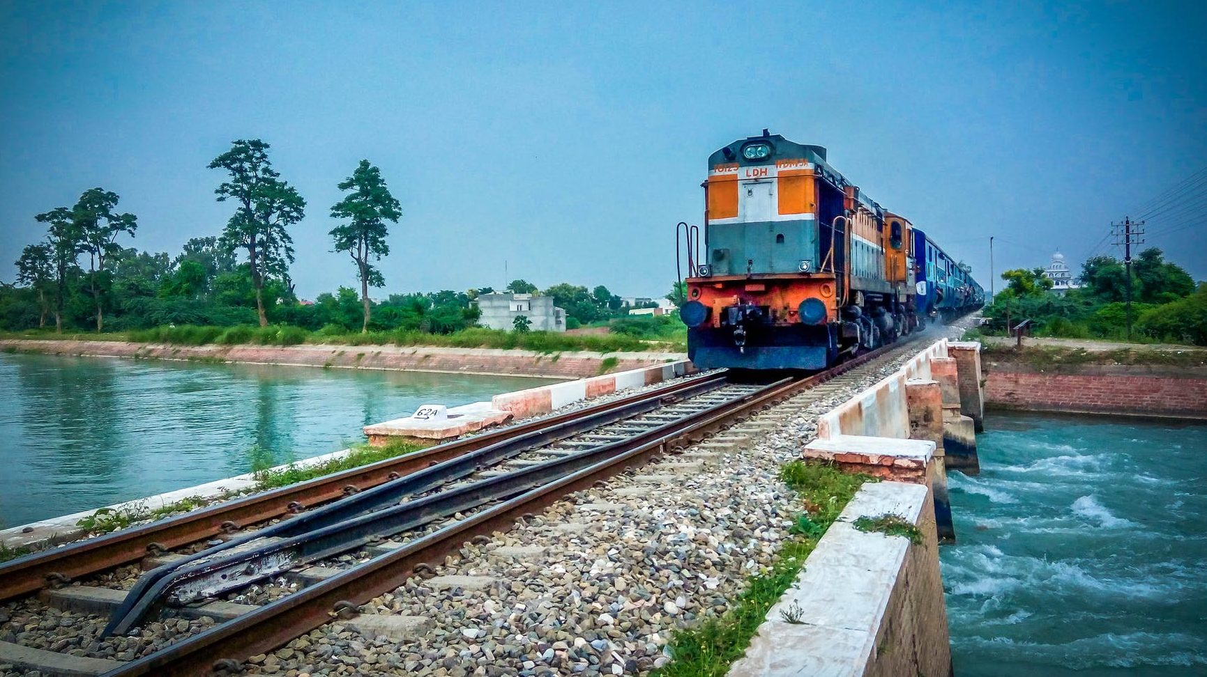 train by trees against blue sky