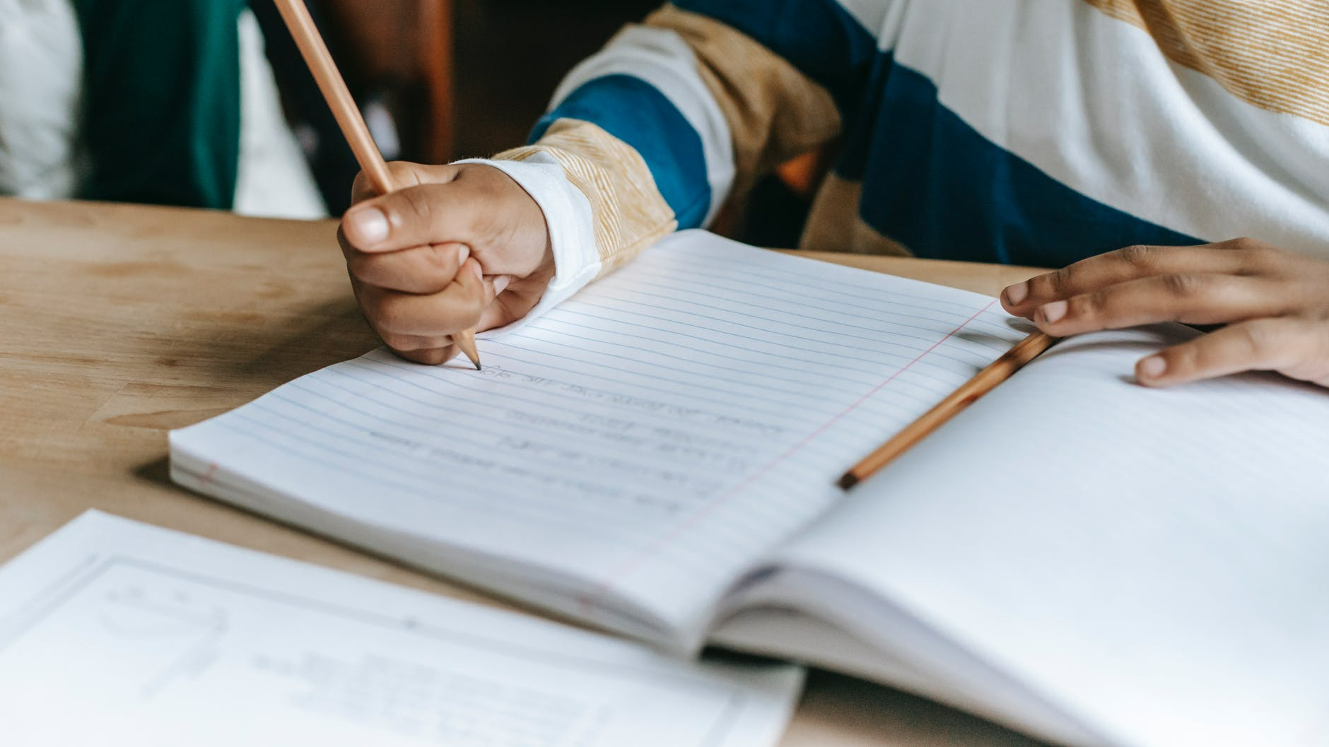 anonymous black pupil solving task during lesson in classroom