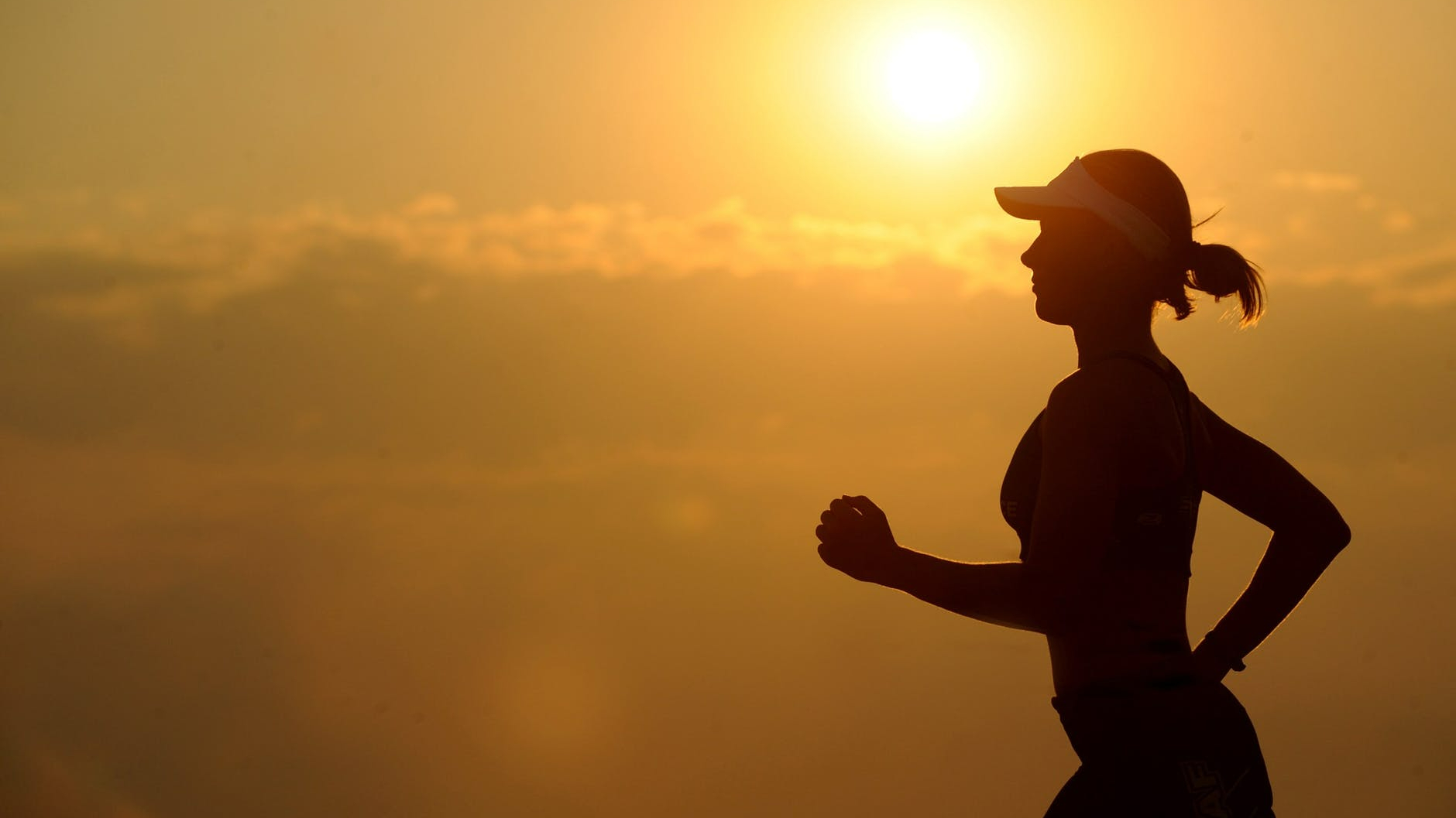 woman with white sunvisor running