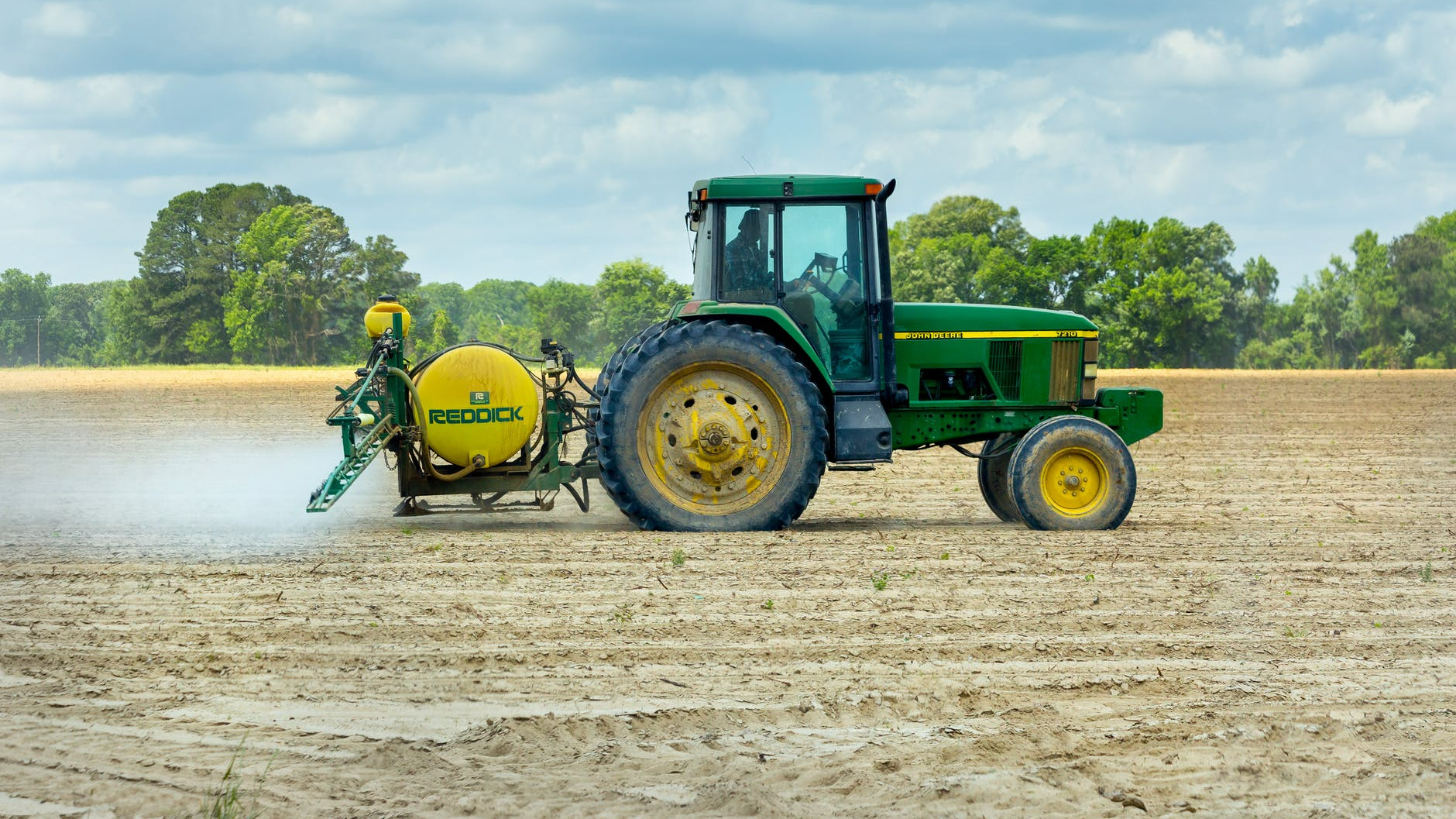 green and yellow tractor on dirt