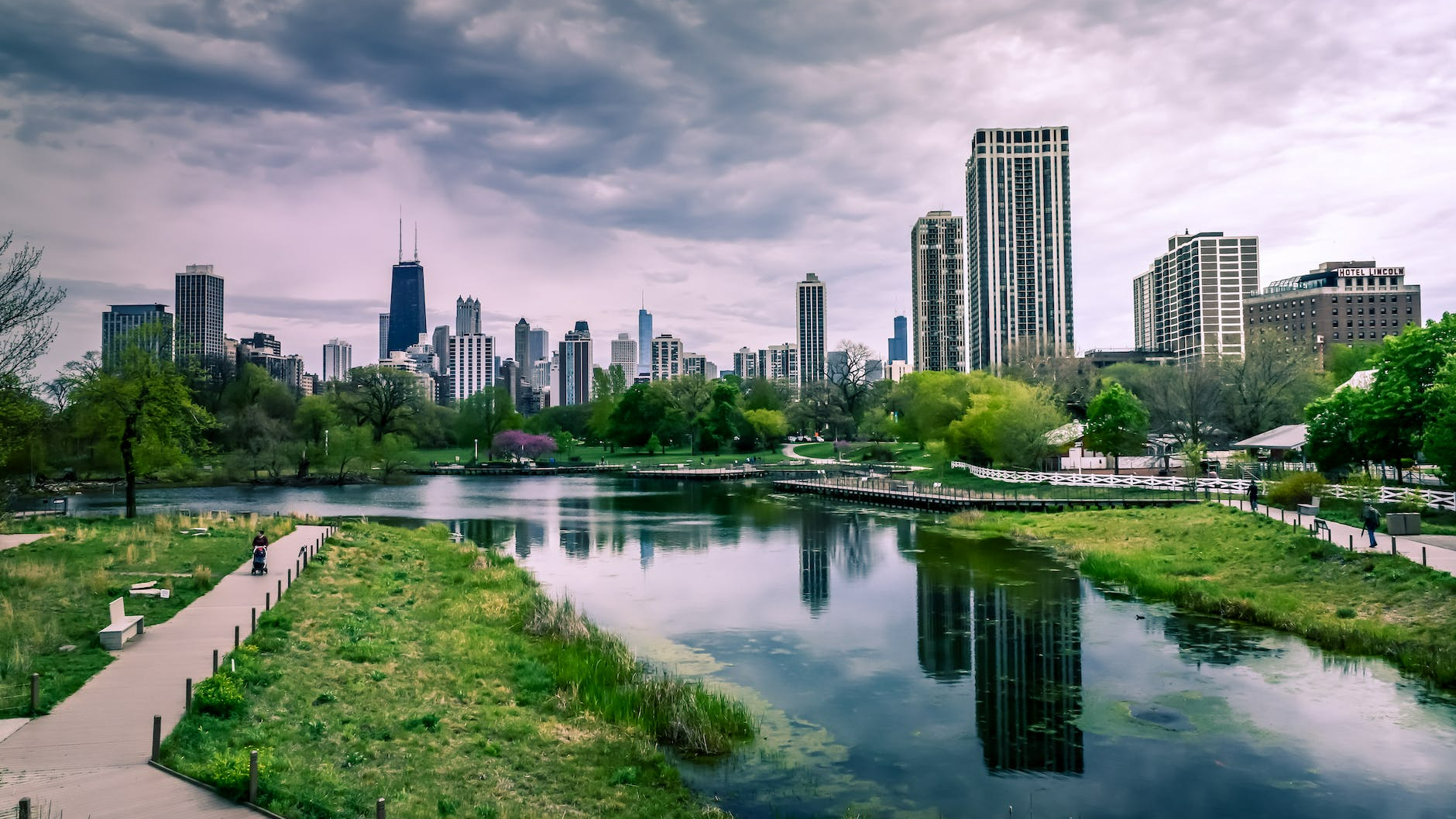 river near city buildings under cloudy sky