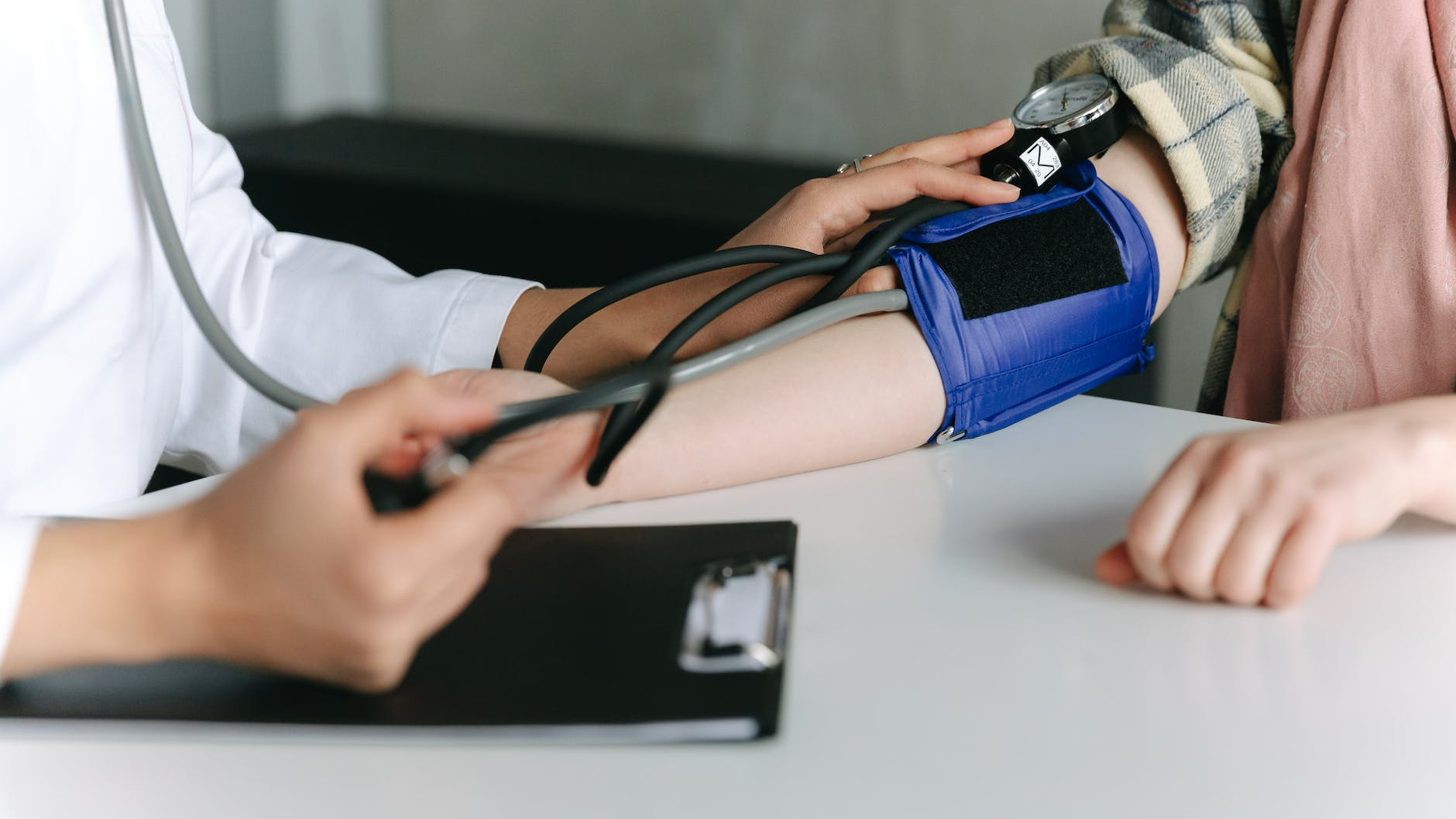 a healthcare worker measuring a patient s blood pressure using a sphygmomanometer